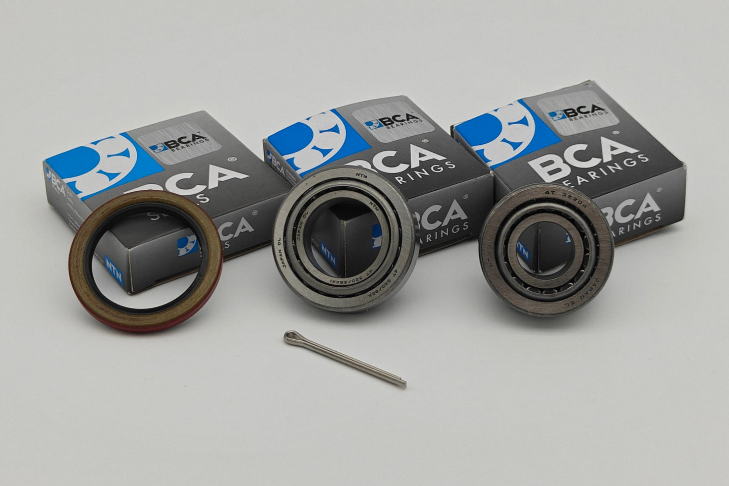Three bearings with BCA packaging on a gray background